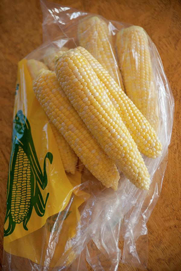 Corn Cobs From A Farmers Market In A Plastic Bag Photograph by William Boch