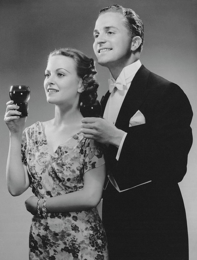 Couple Dressed Up Holding Drinks Photograph by George Marks