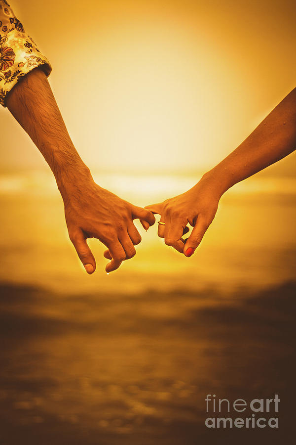 couple holding hands sunset