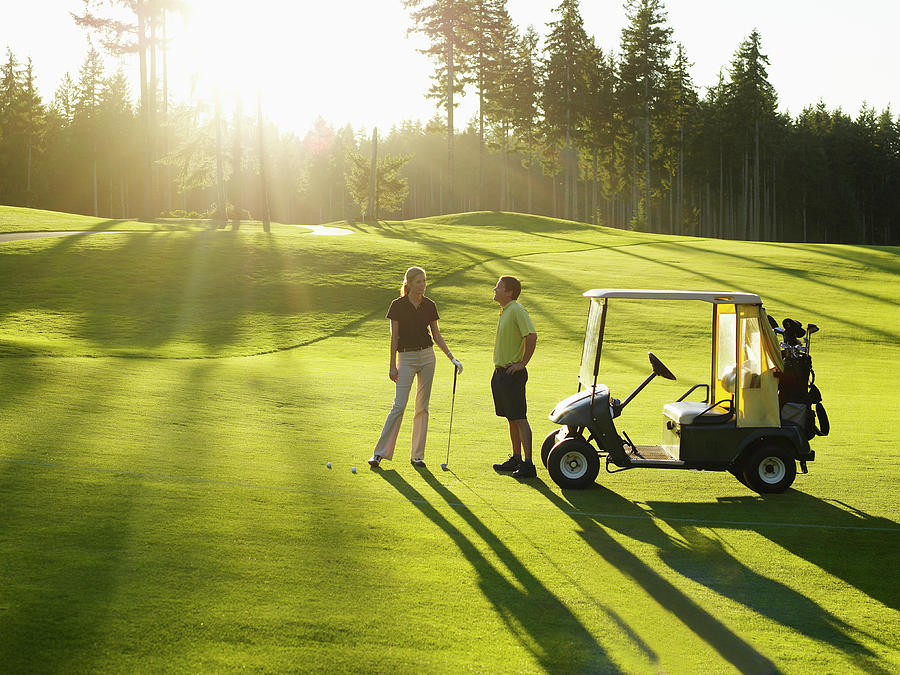 Couple On Golf Course With Golf Cart Photograph by Thomas Barwick