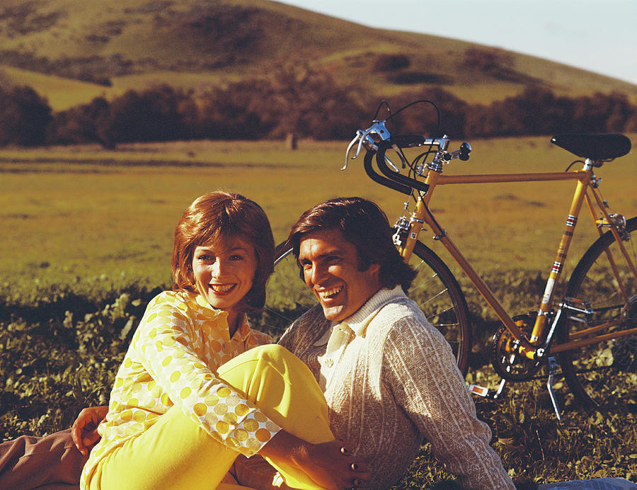 Couple Sitting In Field With Bicycle Photograph by Tom Kelley Archive