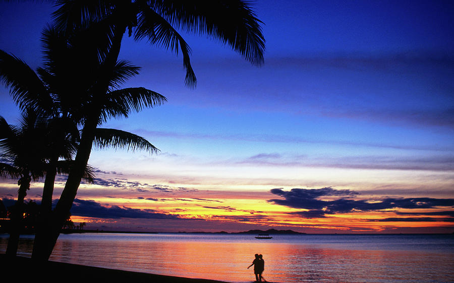 Couple Walking Along Beach At Sunset Photograph by Peter Hendrie Couple Walking Along Beach At Sunset Photograph by Peter Hendrie
