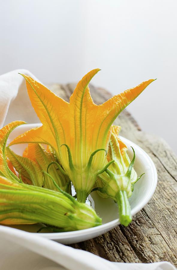 Courgette Flowers In A Ceramic Bowl Photograph by Alice Del Re