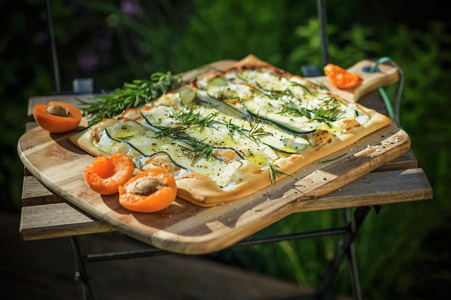 Courgette Unleavened Bread With Goats Cream Cheese, Apricots And Rosemary In Front Of A Courgette Bed Photograph by Jan Wischnewski