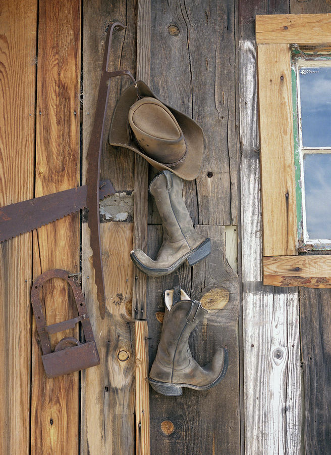Cowboy Boots And Hat Hanging On Cabin Photograph by Jonathan Kantor Studio