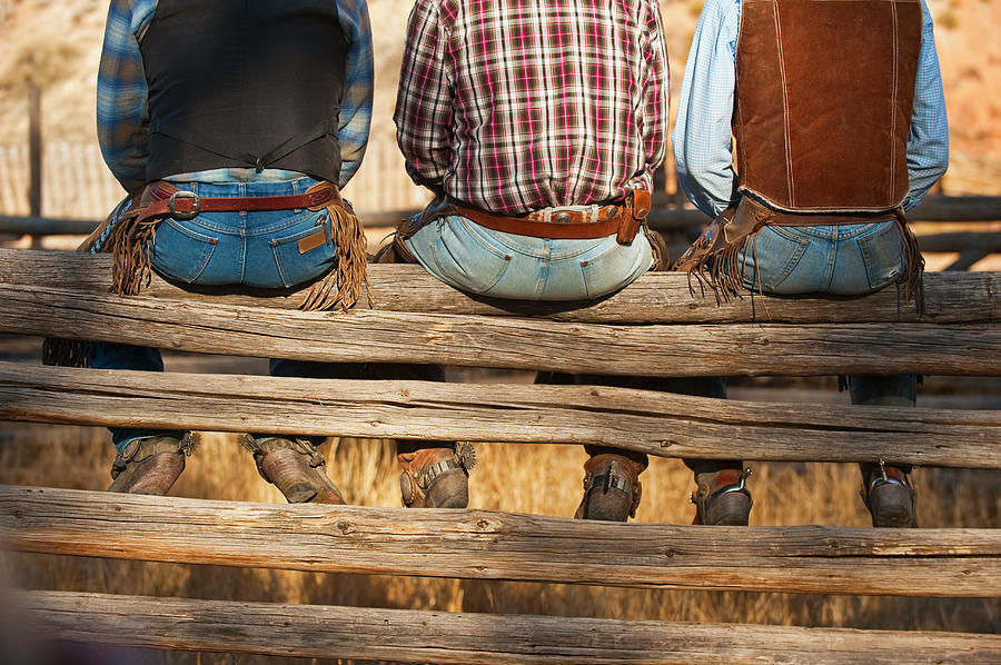 Cowboys Sitting On Fence Photograph by Tetra Images