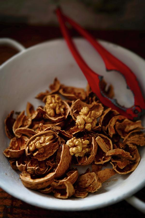 Cracked Walnuts And A Nutcracker In A Bowl Photograph by Roger Stowell