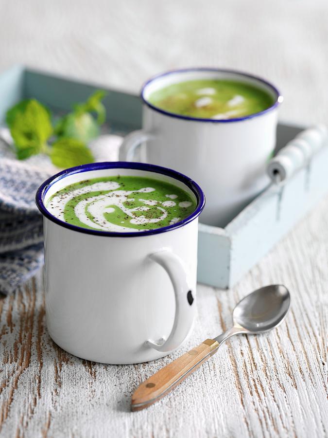 Cream Of Pea Soup With Mint In Enamel Mugs Photograph by Gareth Morgans