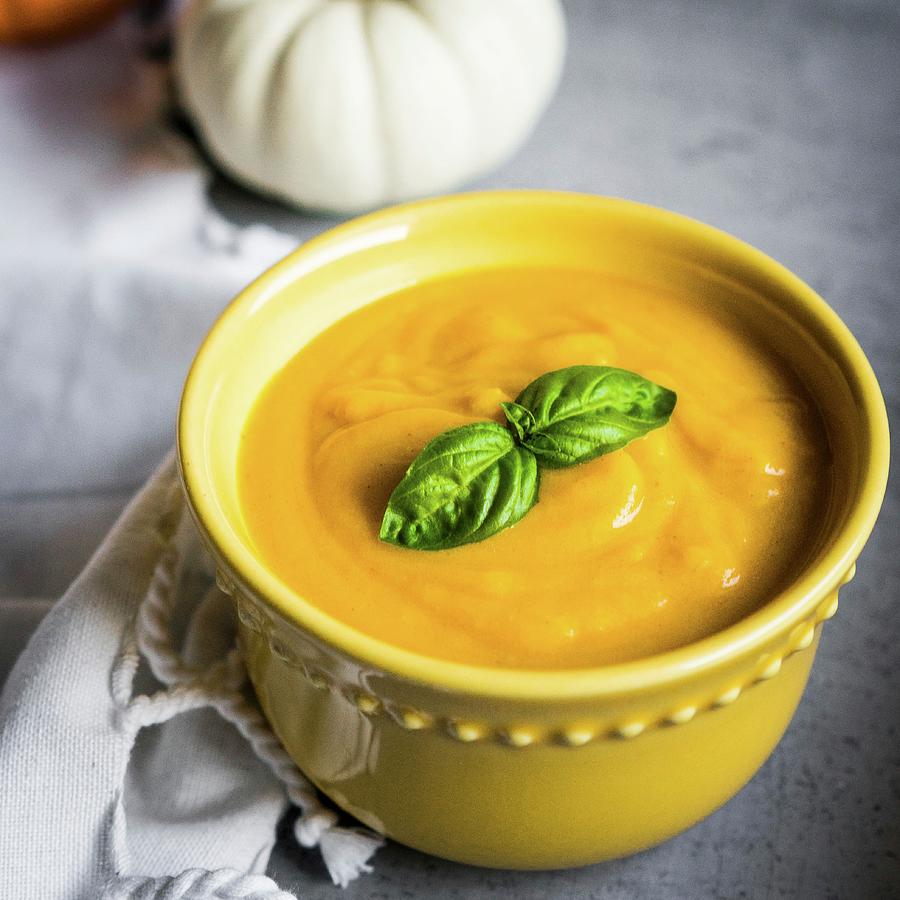 Cream Of Pumpkin Soup Garnished With Basil Photograph by Alena Haurylik