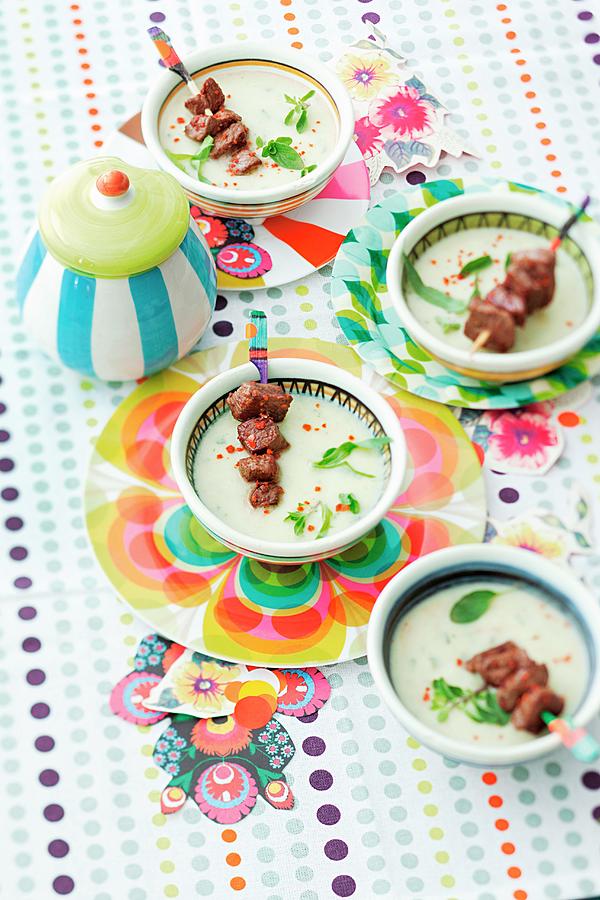 Creamy Celery And Herb Soup With Lamb Skewers On A Colourfully Decorated Table Photograph by Grossmann.schuerle Jalag