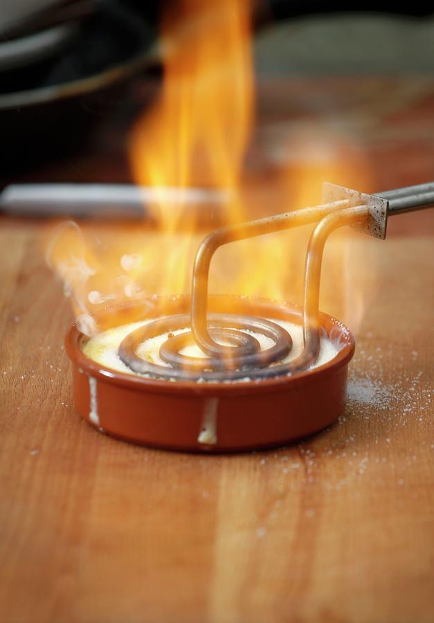 Crema Catalana Being Caramelised With A Branding Iron Photograph by Stepien, Malgorzata
