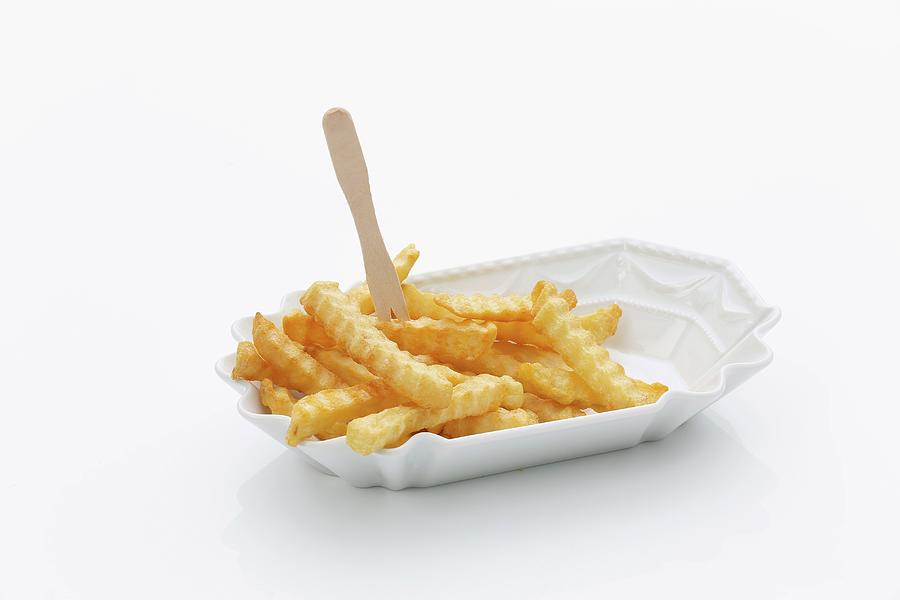 Crinkle Cut Chips With A Wooden Fork In A Porcelain Dish Photograph by Jalag / Michael Bernhardi