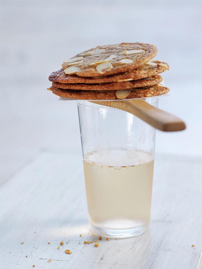 Crispy Almond Biscuits On Top Of A Drink Photograph by Ian Garlick