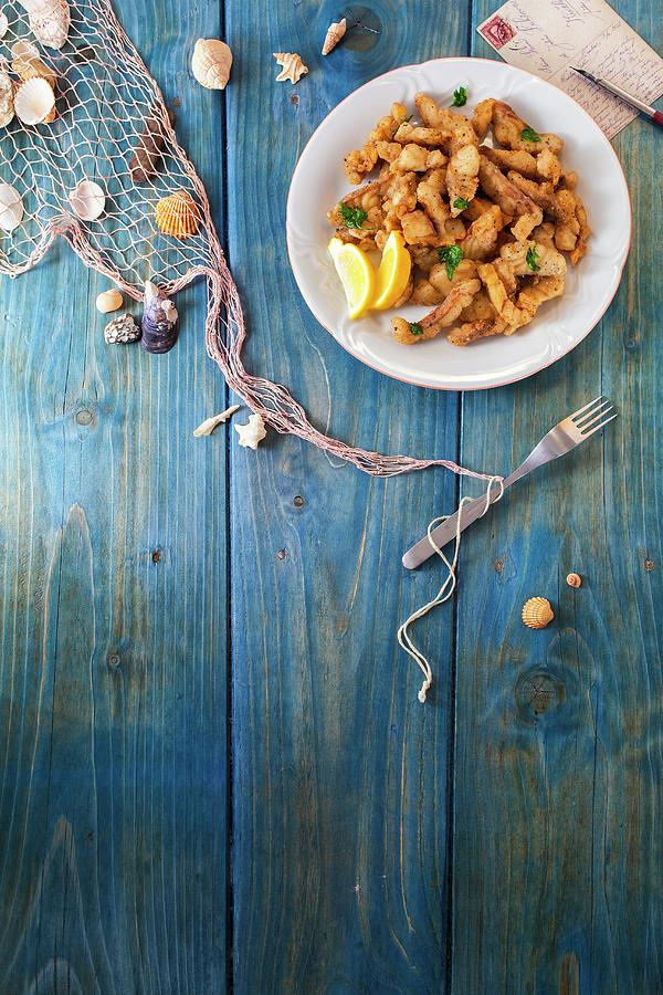 Crispy Fish Fingers On A Blue Wooden Surface With Maritime Decorations Photograph by Jan Prerovsky
