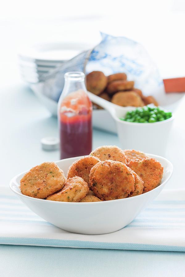 Crispy Fishcakes With Ketchup And Peas Photograph by Andrew Young