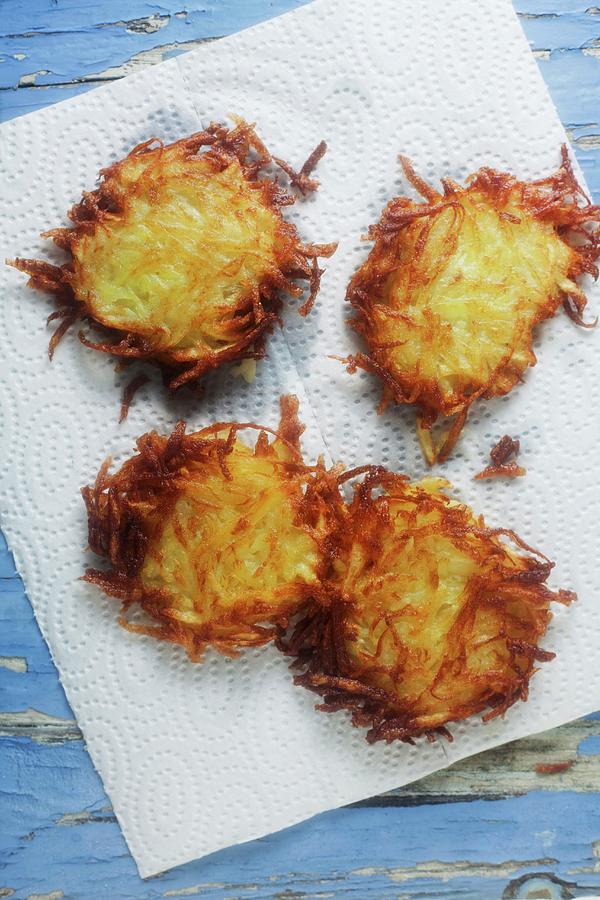 Crispy Fried Potato Cakes On Kitchen Paper Photograph by Barbara Pheby