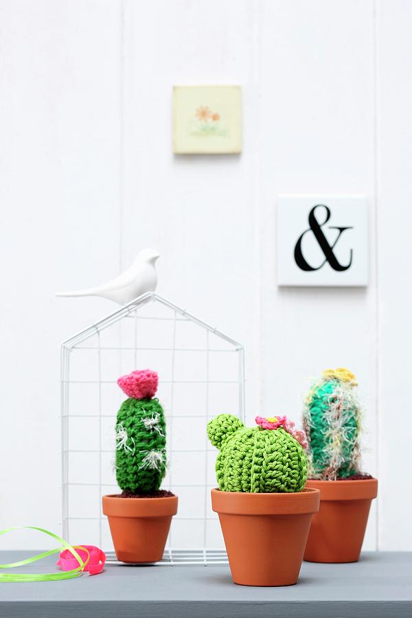 Crocheted Cacti In Terracotta Pots In Front Of Ornamental Wire House Photograph by Thordis Rggeberg