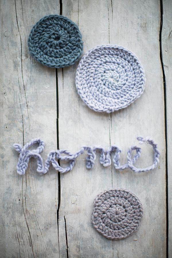 Crocheted Cord Arranged To Spell home And Round Pastel Castors On Vintage Wooden Surface Photograph by Sabine Lscher