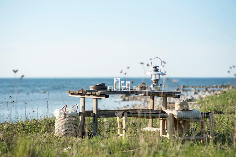 Crockery And Lantern On Wooden Table Next To Sea Photograph by Magdalena Bjrnsdotter