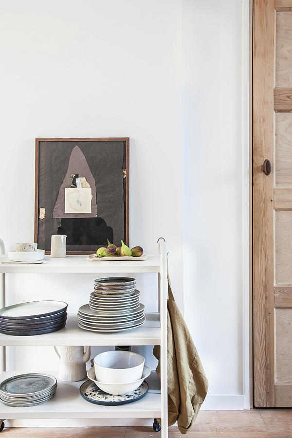 Crockery On White Serving Trolley And Artwork Next To Door Photograph by Holly Marder
