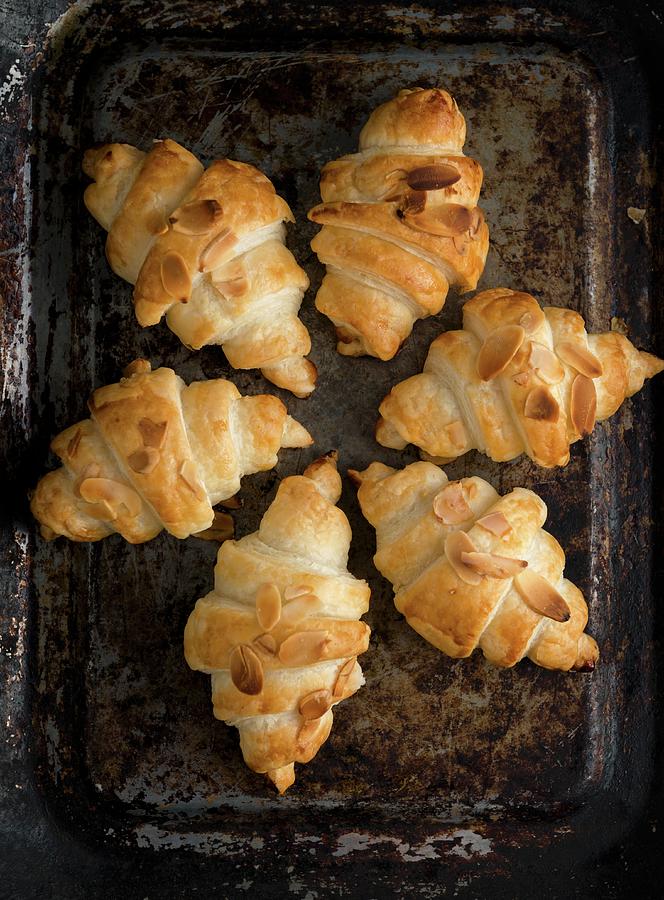 Croissants With Almond Flakes On A Baking Sheet Photograph by Komar