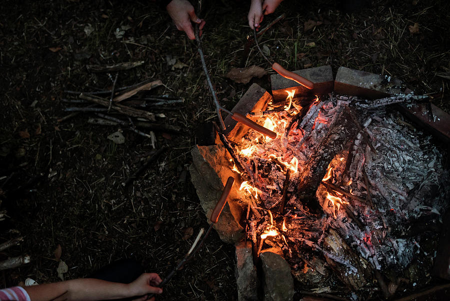 Meat Photograph - Cropped Hands Of Family Roasting Sausages On Stick Over Campfire In Forest by Cavan Images