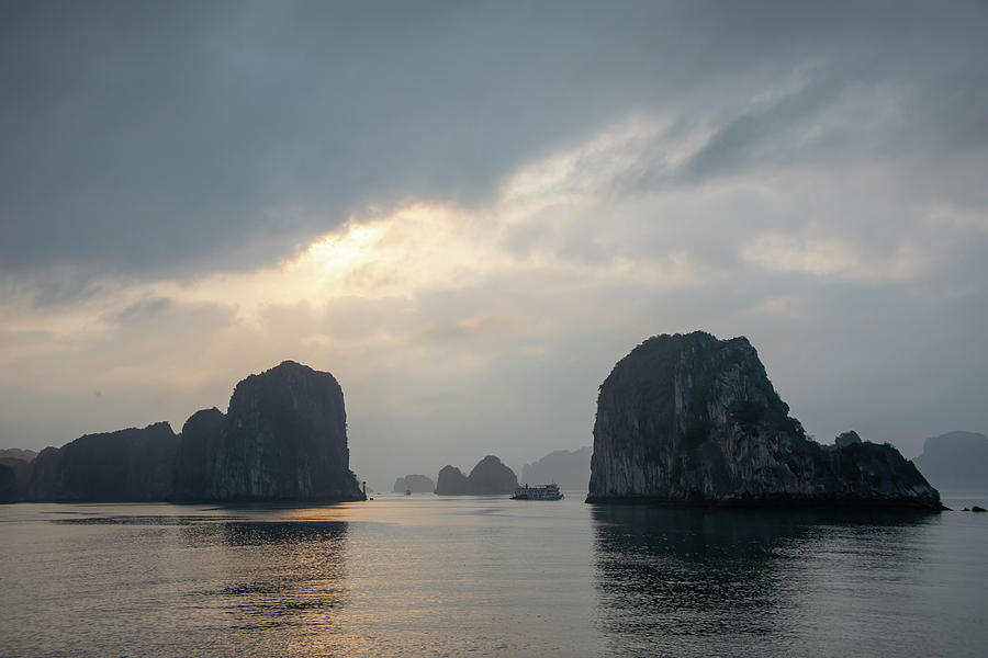 Cruise ship at sunset between karst rock foramtions in Ha Long B Photograph by Karen Foley