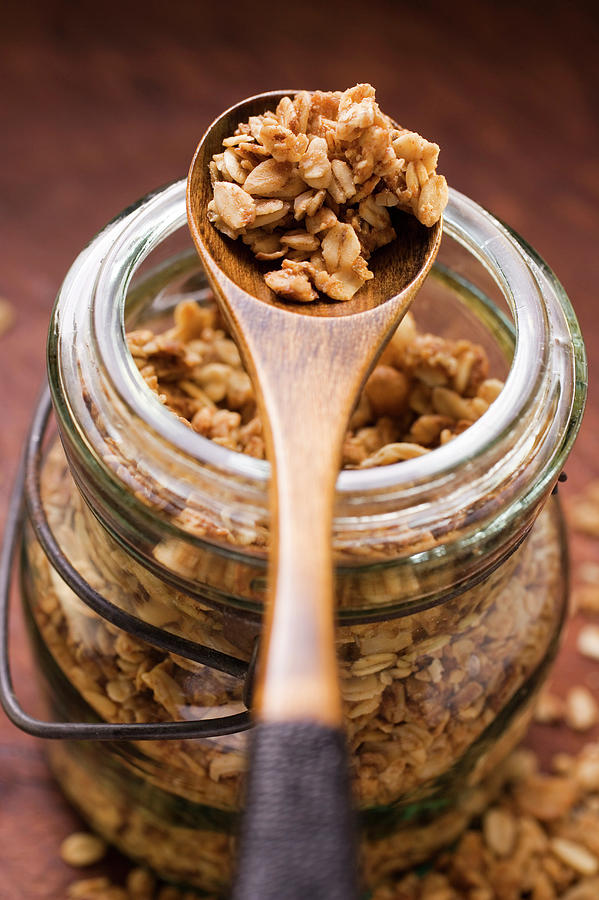 Crunchy Muesli In A Jar And On A Wooden Photograph by Foodcollection
