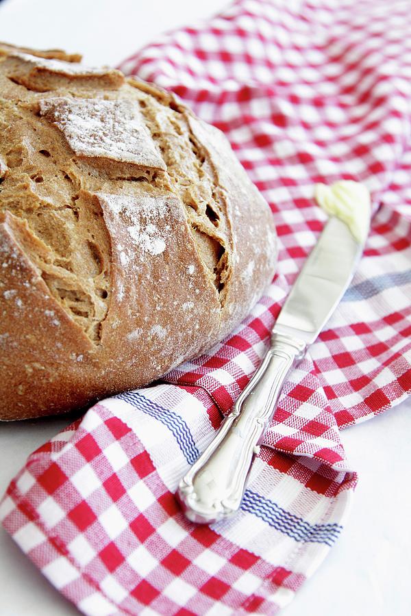 Crusty Bread And A Knife With Butter On A Checked Cloth Photograph by Simone Van Rees