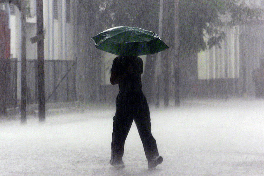 Cuban Man Walks Under Heavy Rain Photograph by Jorge Silva - Fine Art ...