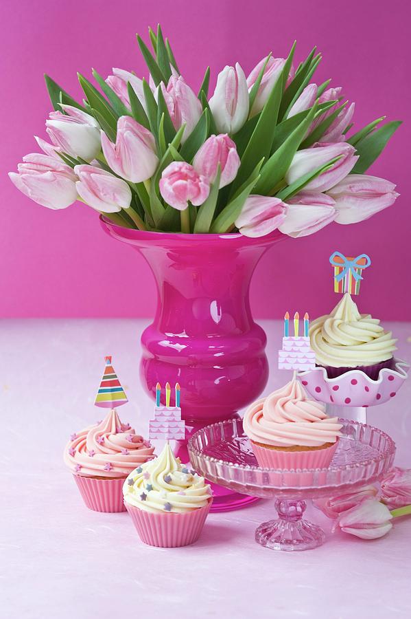 Cupcakes With Party Toppers And Bouquet Of Tulips Photograph by Jasmine Burgess