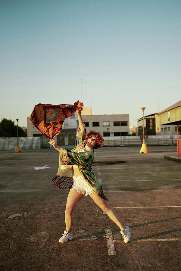 Summer Photograph - Curly Redhead Young Female With Attitude Dancing In Empty Parking Lot by Cavan Images