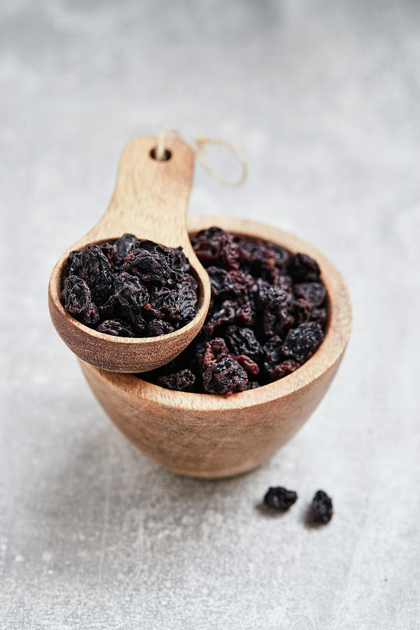 Currants In A Wooden Bowl And A Wooden Scoop Photograph by Brigitte Sporrer
