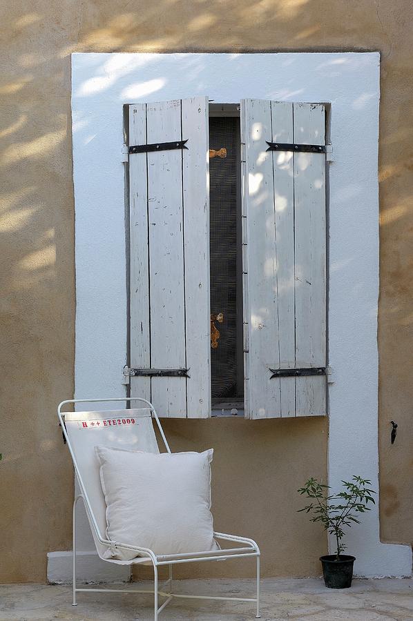 Cushion On Delicate, White Metal Chair Against House Facade Below Window With Closed, White Wooden Shutters Photograph by Henri Del Olmo