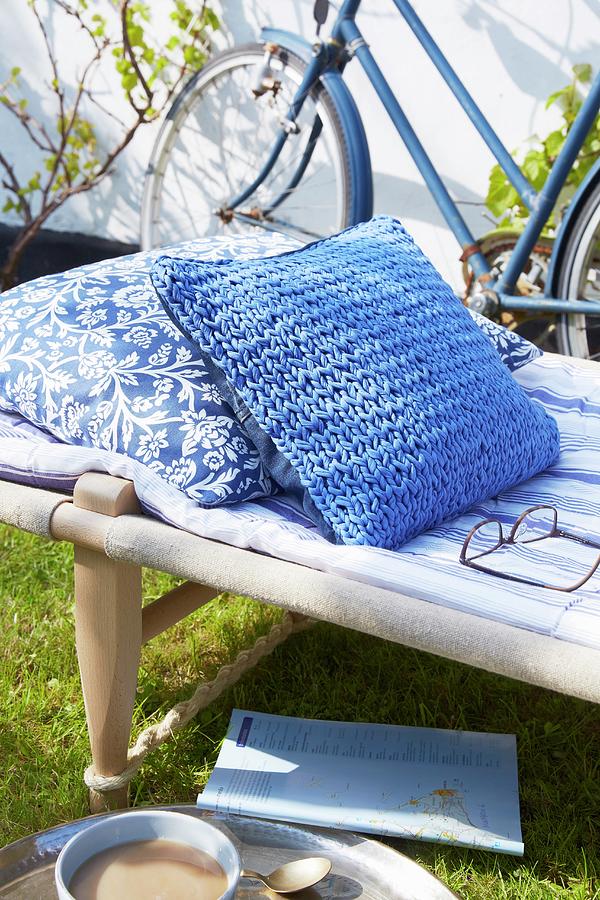 Cushion With Blue Knitted Cover On Camp Bed In Garden Photograph by Greenhaus Press