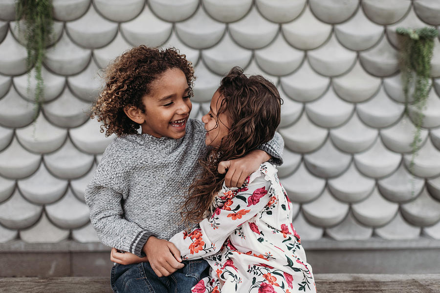 Cute Siblings Smiling And Laughing At Each Other While Hugging Outside ...