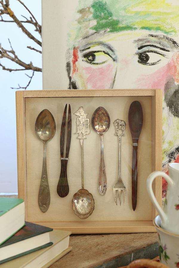 Cutlery Mounted In Wooden Box In Front Of Modern Portrait On Canvas Photograph by Regina Hippel