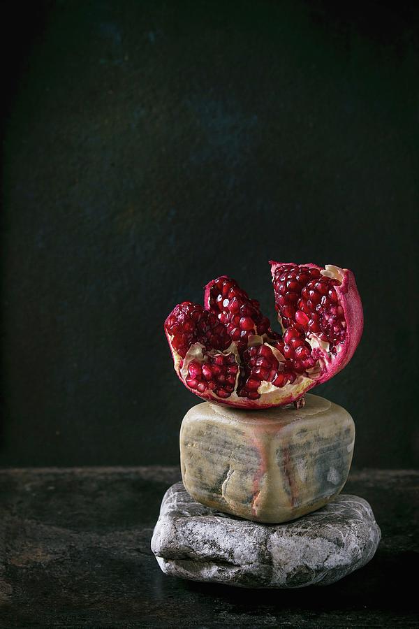 Cutting Pomegranate On Decorative Stones Over Black Background Photograph by Natasha Breen