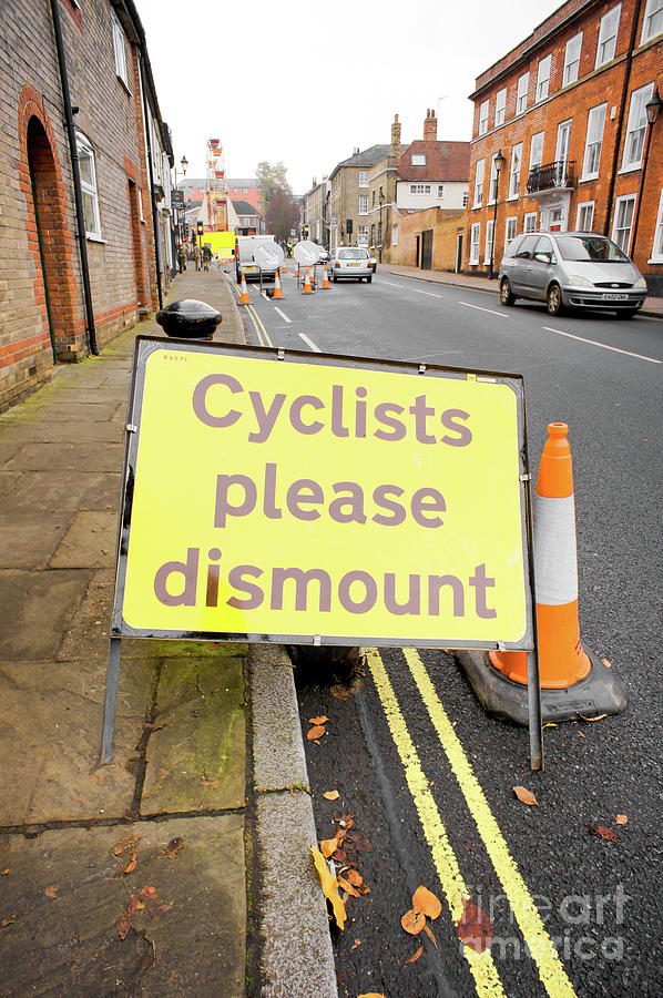 Space Photograph - Cyclist dismount sign by Tom Gowanlock