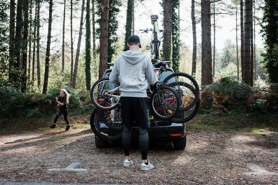 Summer Photograph - Dad Getting Bikes Off The Car Ready For A Family Bike Ride by Cavan Images