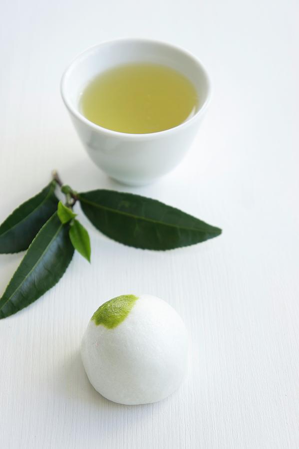 Daifuku Mochi japanese Sweet With A Sprig Of Tea Leaves And A Bowl Of Green Tea Photograph by Martina Schindler