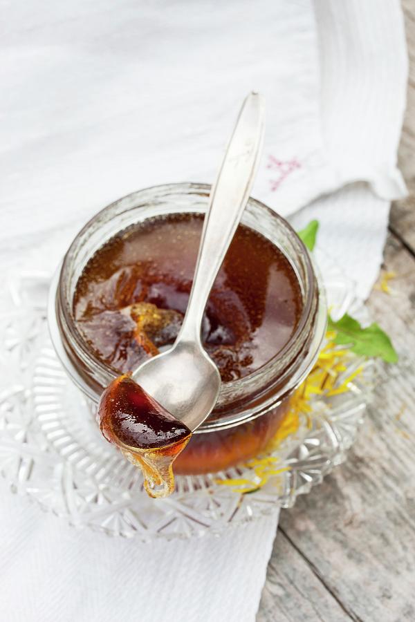 Dandelion Petal Jelly Dripping From Spoon Photograph by Sabine Lscher