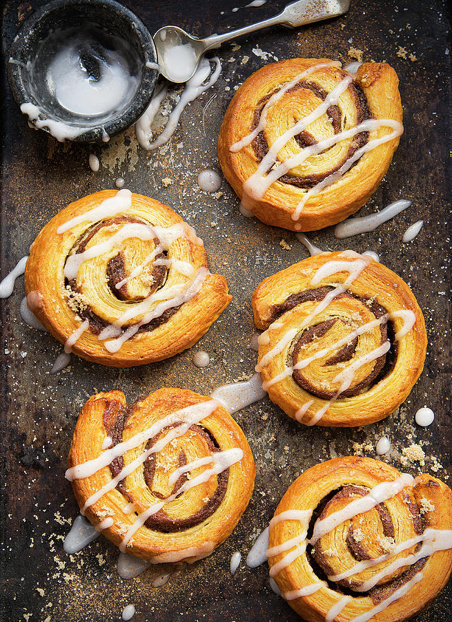 Danish Pastries Cinnamon Swirls On A Baking Tray Decorated With Icing Photograph by Stacy Grant