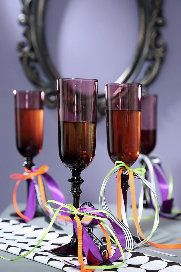 Dark Champagne Flutes Decorated With Ribbons For Halloween Photograph by Thordis Rggeberg