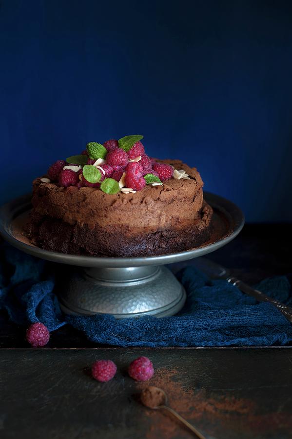 Dark Chocolate Cake On A Metal Cake Stand With Fresh Raspberries And Mint Photograph by Magdalena Hendey