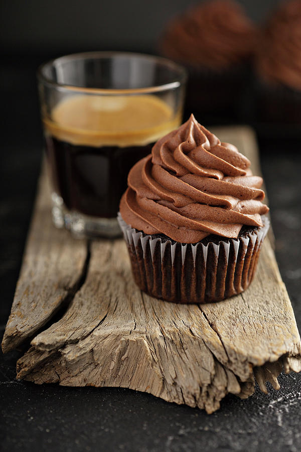 Dark Chocolate Cupcakes With Ganache Frosting On Dark Background With Espresso In A Glass Photograph by Elena Veselova