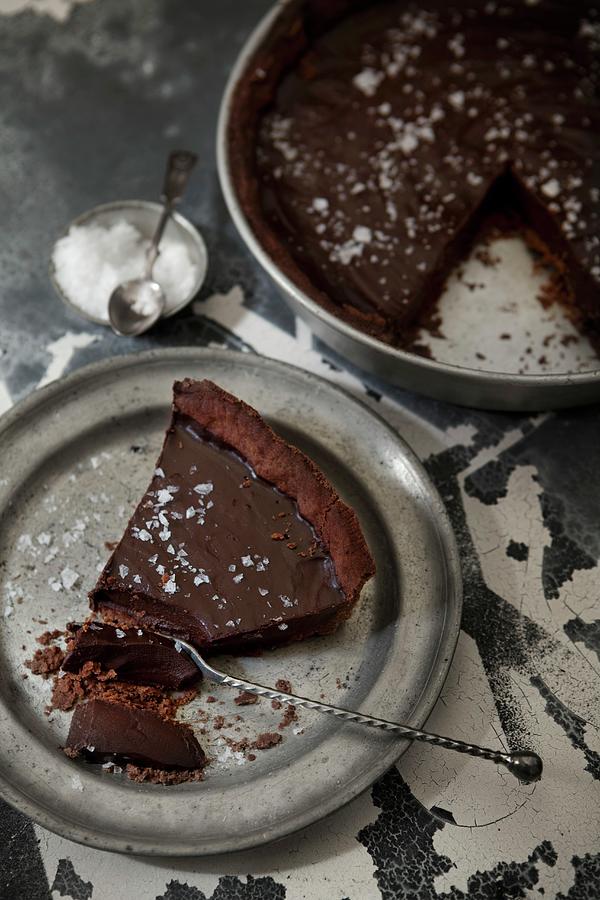 Dark Chocolate Truffle Cake Sprinkled With Salt, A Slice On A Silver Plate Photograph by Ulrika Ekblom