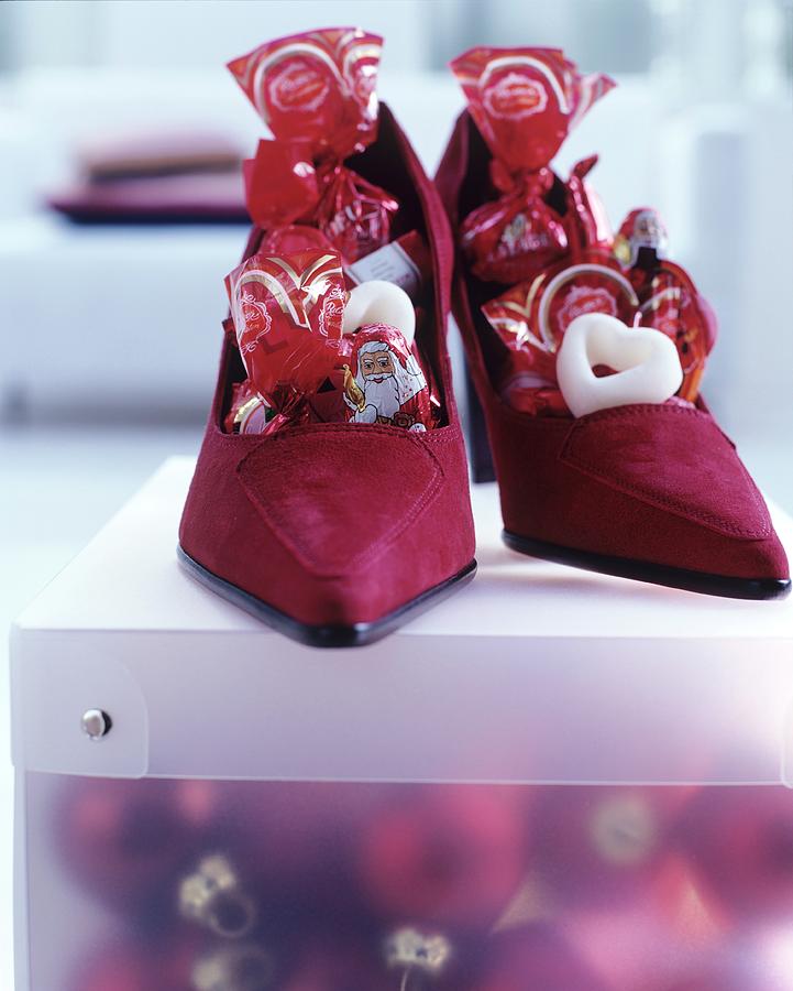 Dark Red Suede Ladies Shoes Filled With Chocolate Father Christmases And Sweets Photograph by Matteo Manduzio