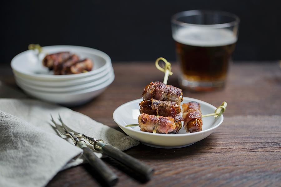 Dates Wrapped In Bacon Served With A Glass Of Beer Photograph by Nicole Godt