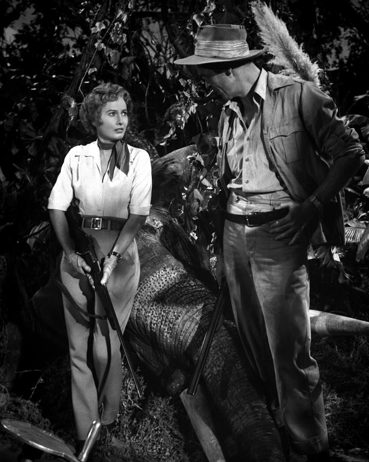 Barbara Stanwyck Photograph - David Farrar Talking To Barbara Stanwyck Holding Rifle by Globe Photos
